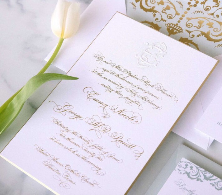 white paper wedding invitation with gold calligraphy