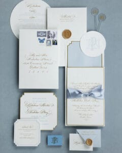 white paper and gold calligraphy wedding suite with blue background