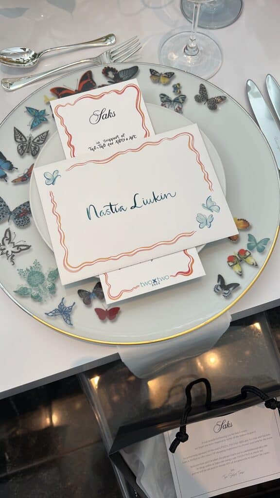 place setting with butterfly painted plates, menu and place card featuring nastia lukin name in calligraphy